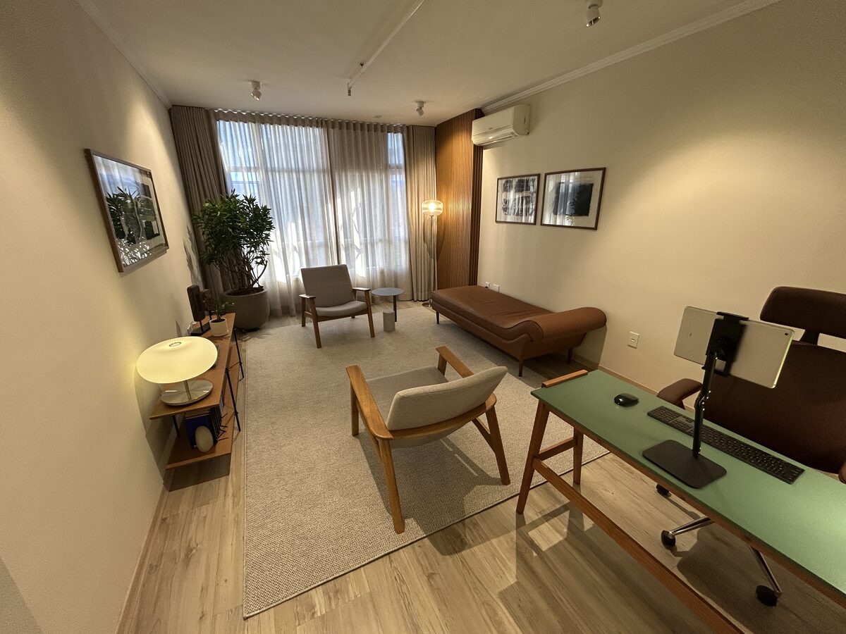 Vista geral da sala com poltronas e divã